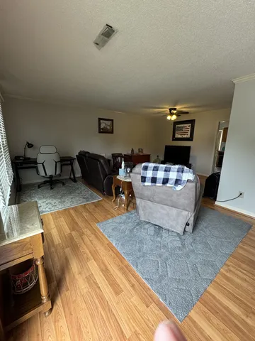 a living room with furniture and a wooden floor