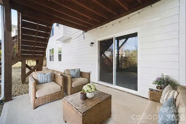 a view of a patio with couches and a dining table and chairs with wooden floor