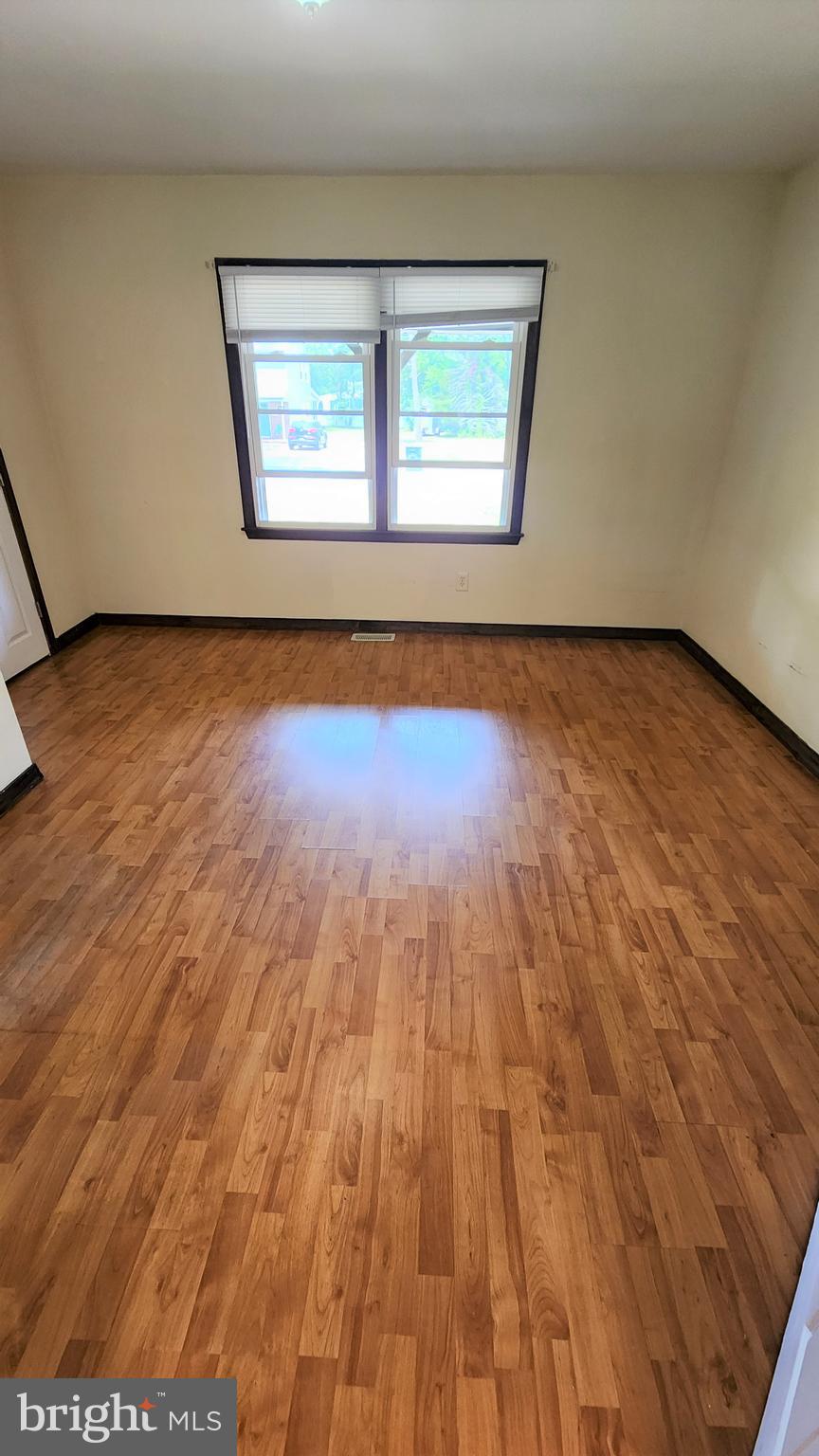 408 Deptford Road Glassboro, NJ 08028 - Photo 5 of 13 an empty room with wooden floor and windows
