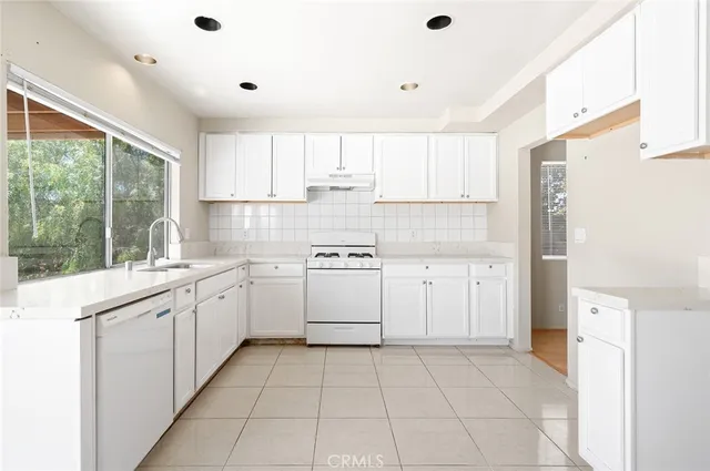 a kitchen with a sink window and cabinets