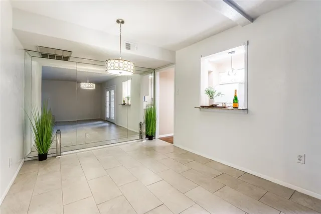 a view of a hallway with wooden floor and a chandelier
