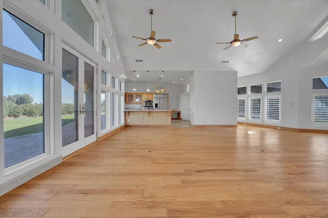 a view of an empty room with a window and a ceiling fan