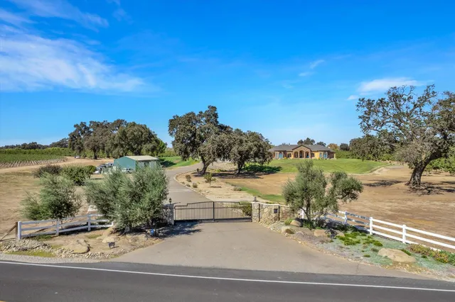 a view of a house with a big yard and large trees