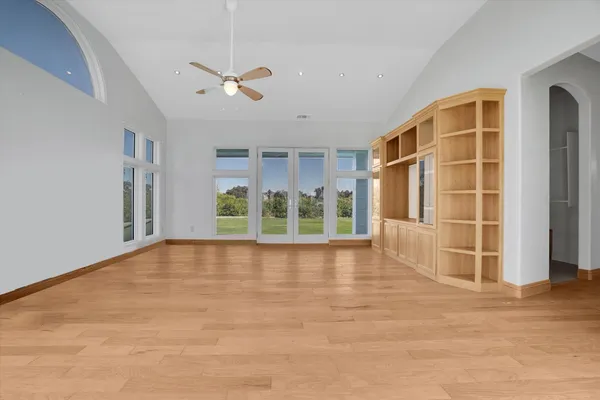 a view of an empty room with a window and a ceiling fan