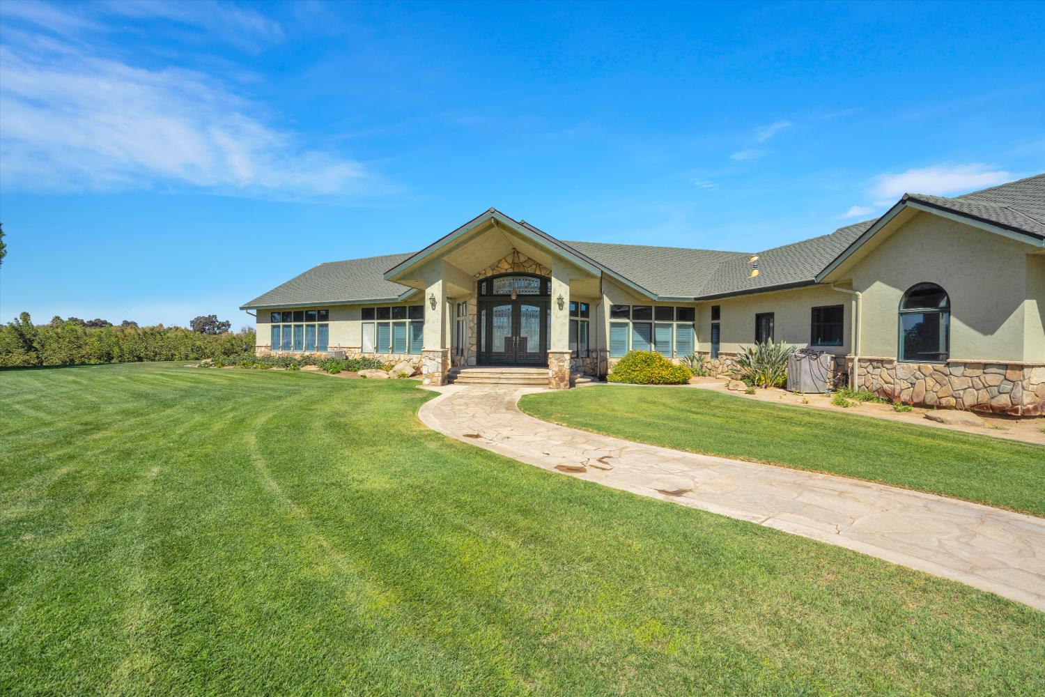 20170 River Road Stevinson, CA 95374 - Photo 3 of 77 a front view of a house with a garden and yard