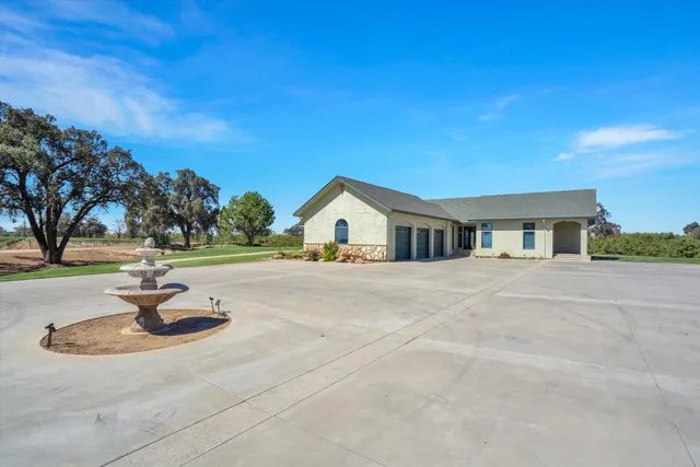 a view of an empty room with kitchen and windows