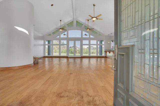 a view of an empty room with a window and kitchen view