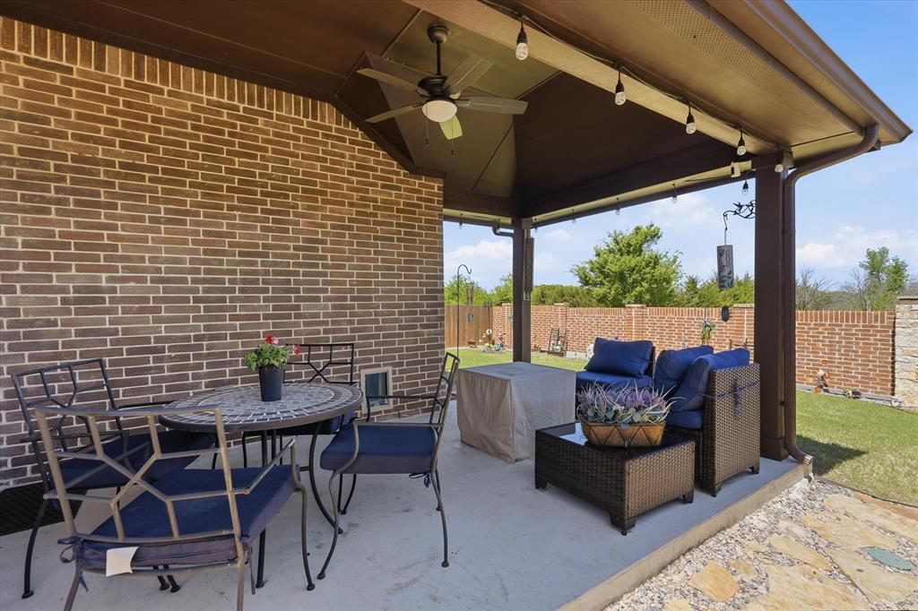 813 Mildren Lane Fate, TX 75087 - Photo 21 of 32 The expanded covered patio offers a ceiling fan as well as decorative lighting (which remain with the property).