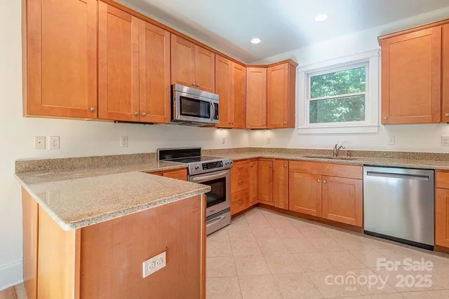 a kitchen with stainless steel appliances granite countertop a sink stove and microwave