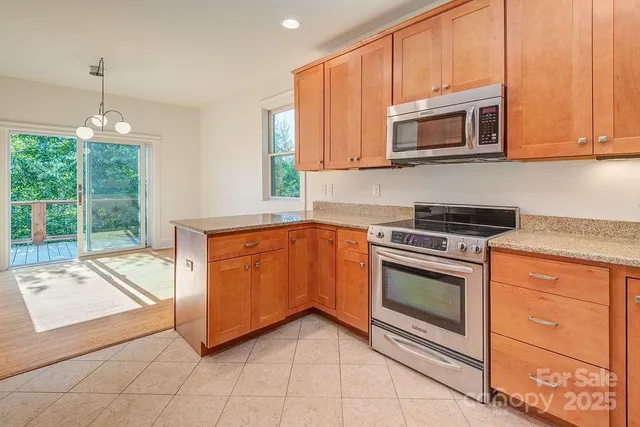 a kitchen with granite countertop a stove top oven microwave and cabinets