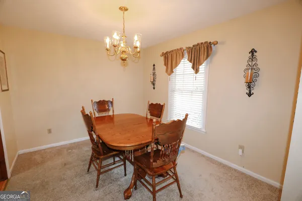 a view of a dining room with furniture and a chandelier