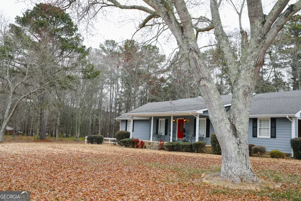 a front view of a house with a yard and trees