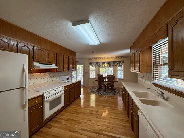 a kitchen with stainless steel appliances granite countertop a sink a stove and refrigerator
