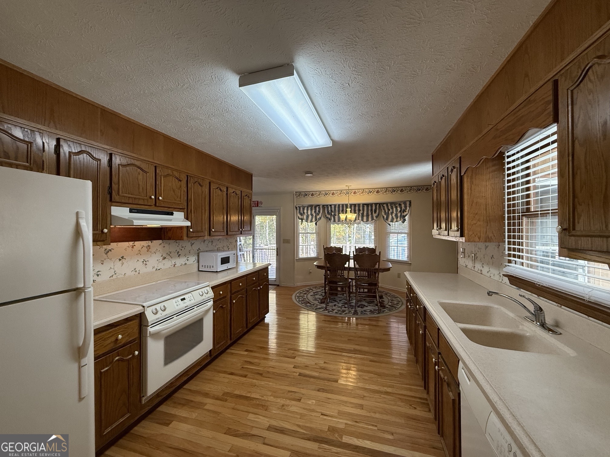 1084 Macedonia Road Newnan, GA 30263 - Photo 6 of 24 a kitchen with stainless steel appliances granite countertop a sink a stove and refrigerator