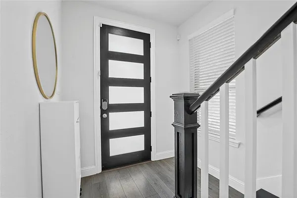 a view of a hallway with wooden floor and entryway
