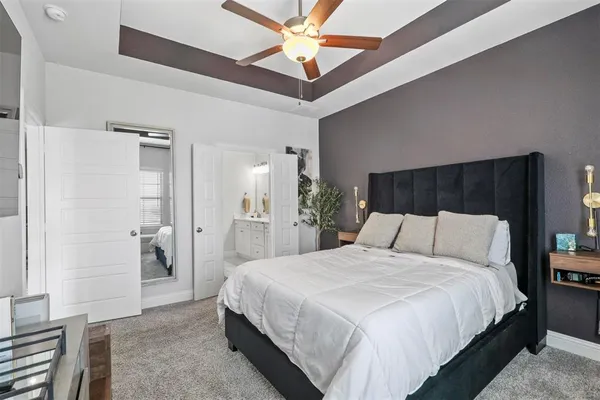 a bedroom with a large bed and a chandelier