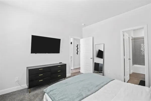 a bedroom with a bed and a flat screen tv