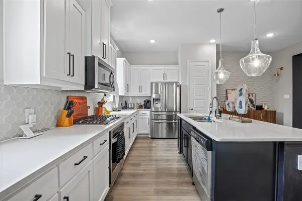 a kitchen with stainless steel appliances a sink stove and cabinets