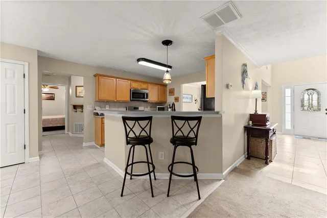 a view of a dining room with furniture a kitchen and chandelier