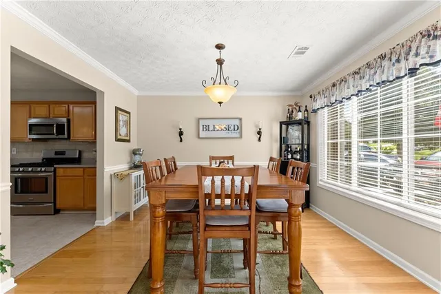 a view of a dining room with furniture a chandelier and wooden floor