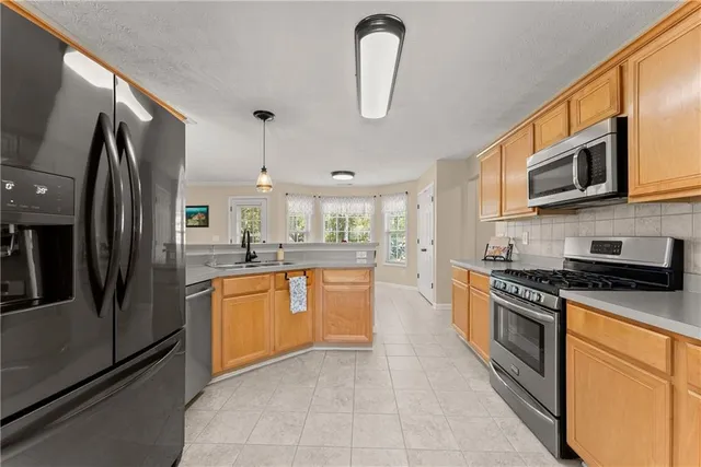a kitchen with stainless steel appliances granite countertop a stove a sink and a refrigerator