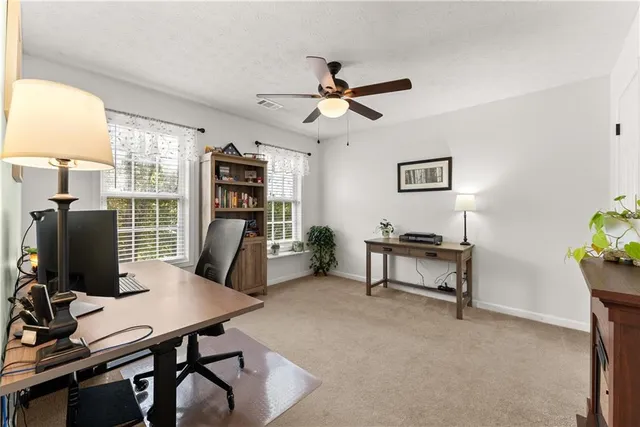 a view of a white house with a chairs in patio