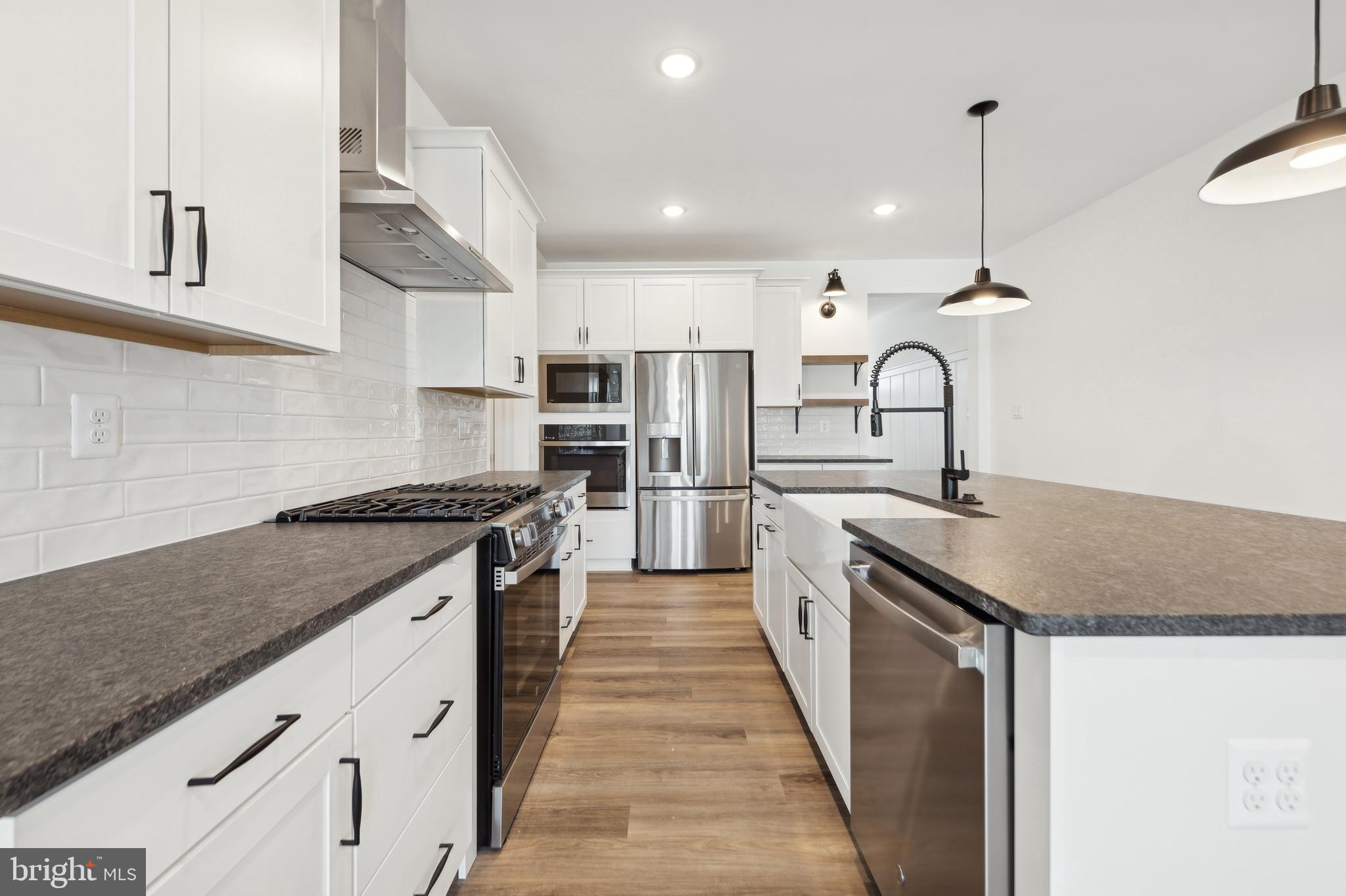 20430 Spyglass Circle Georgetown, DE 19947 - Photo 5 of 24 a kitchen with stainless steel appliances granite countertop a sink a stove and a refrigerator