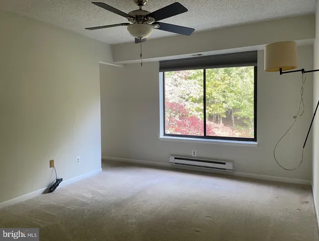 an empty room with windows and fan