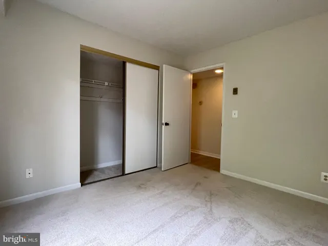 an empty room with closet and wooden door