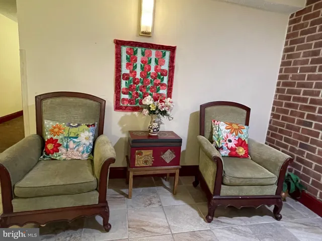 a living room with furniture and wall paintings