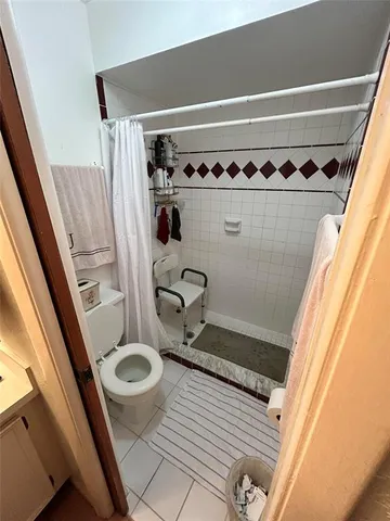 a bathroom with a sink a toilet a shower and vanity