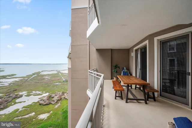 a view of a house with a wooden deck and furniture