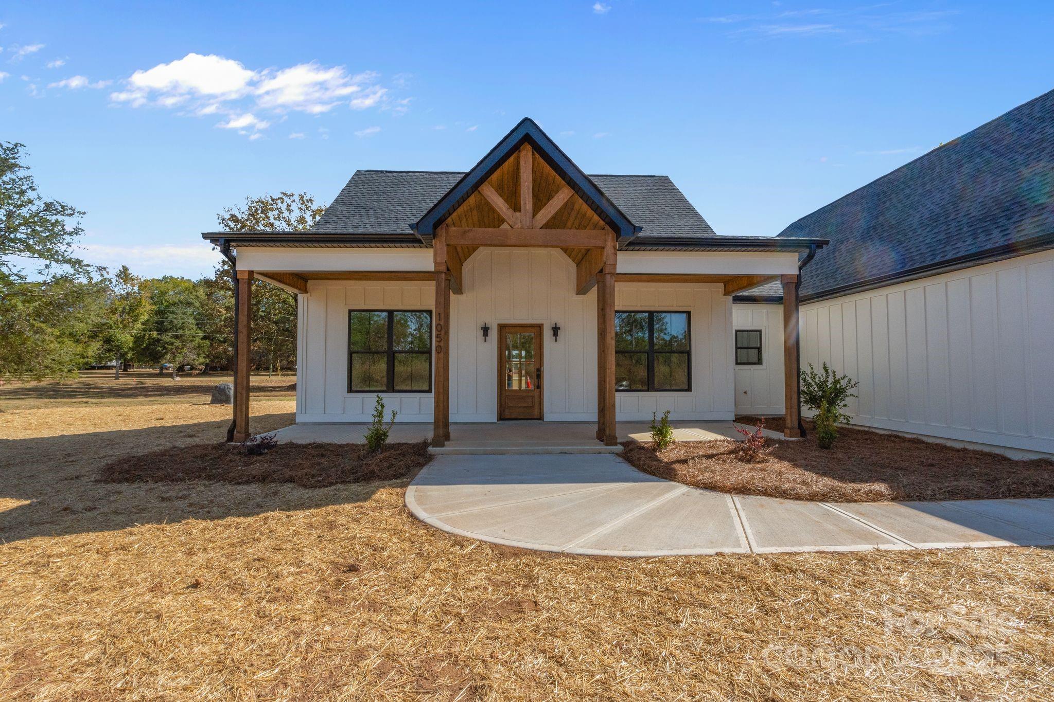 1050 Tom Joye Road Clover, SC 29710 - Photo 2 of 29 a view of a brick house with large windows and a yard with plants