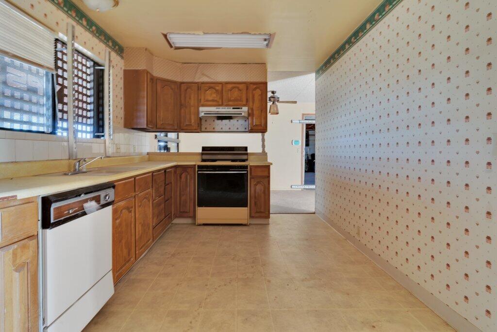 925 Inca Trail Yucca Valley, CA 92284 - Photo 17 of 31 a kitchen with stainless steel appliances a sink stove and cabinets
