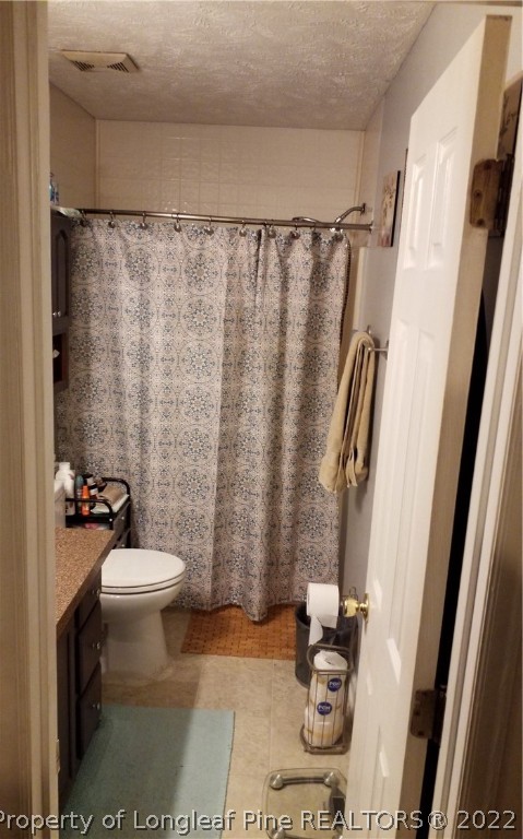 748 Rim Road Fayetteville, NC 28314 - Photo 15 of 18 a bathroom with a sink a toilet a rug and shower curtain
