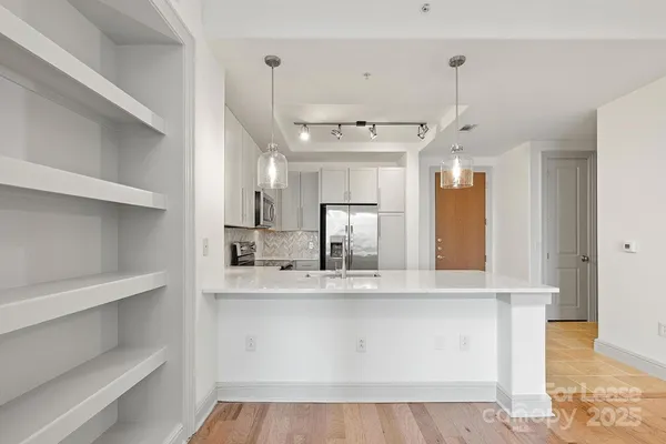 a view of a kitchen with a sink and refrigerator