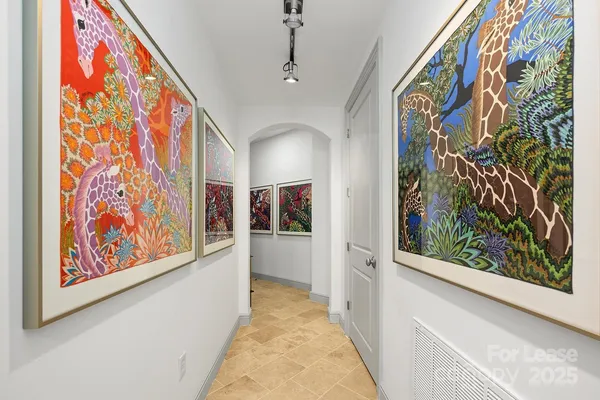 a hallway with painting on the wall and a painting on the wall