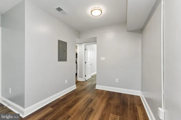 an empty room with wooden floor and entrance