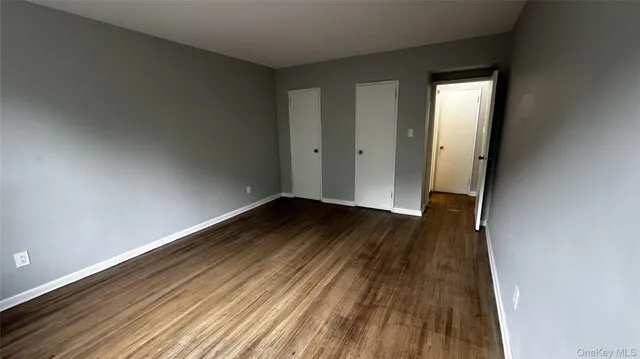 a view of a room with wooden floor and a window