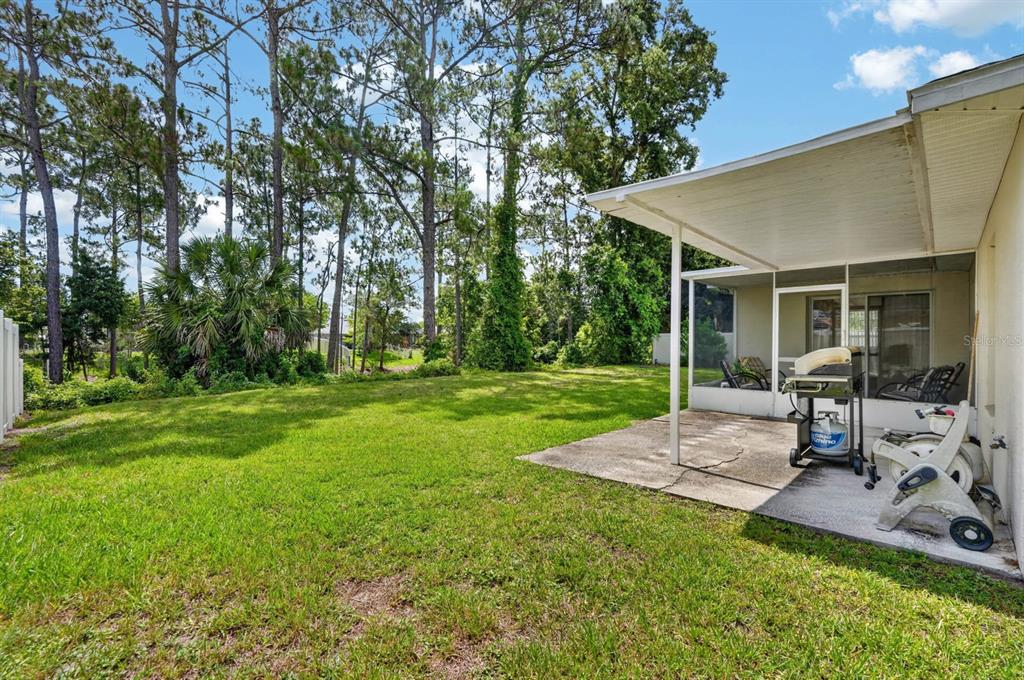80 Roxboro Drive Palm Coast, FL 32164 - Photo 24 of 39 a view of a chair and table in backyard of the house