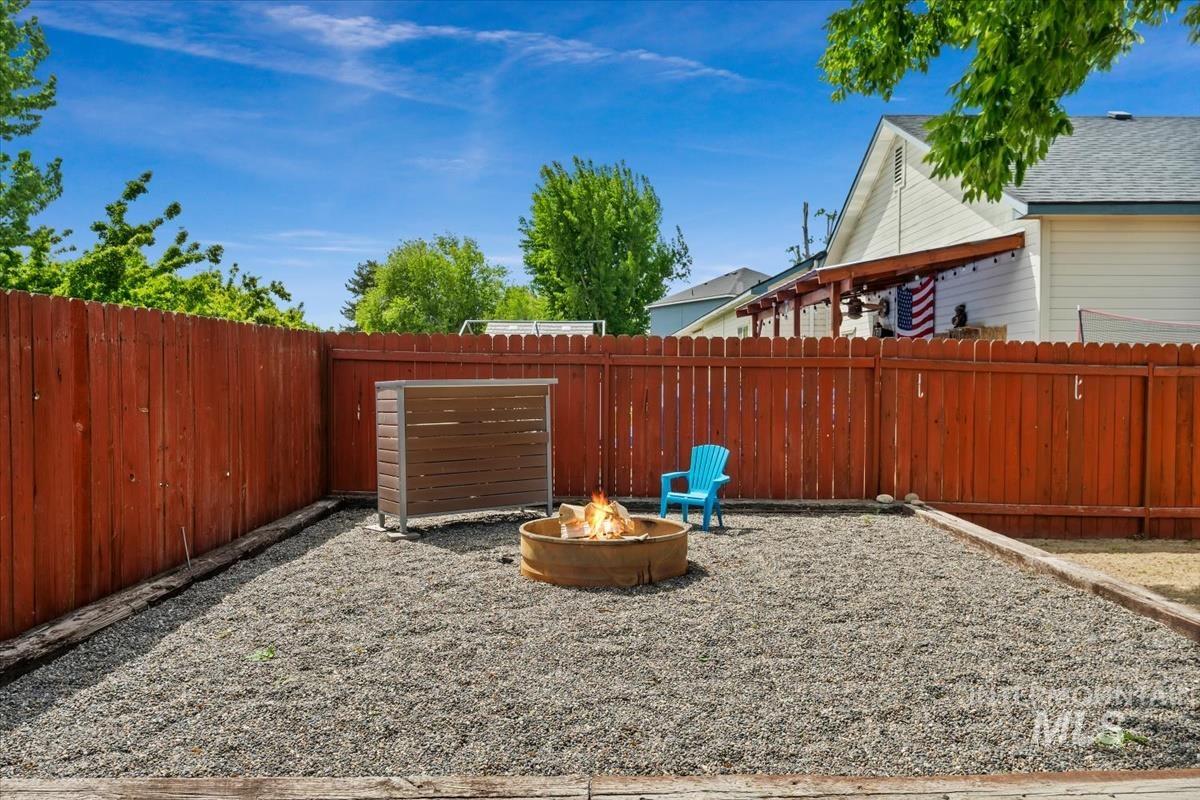 80 Cobblestone Court Middleton, ID 83644 - Photo 34 of 48 Gravel backyard featuring a circular fire pit, privacy fencing, and a built-in storage unit