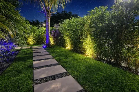 a view of yard with small fountain and wooden fence