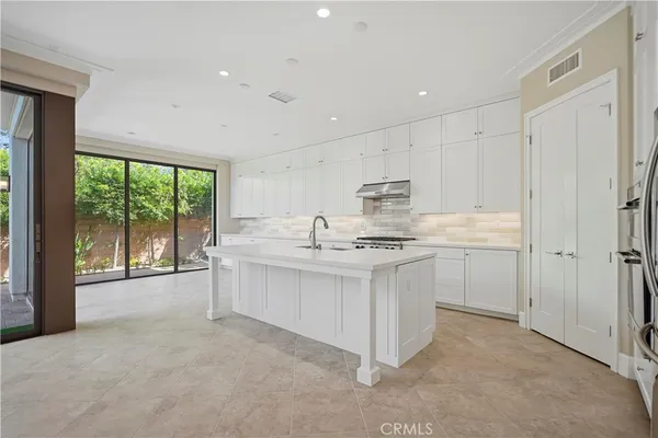 a large white kitchen with a large window