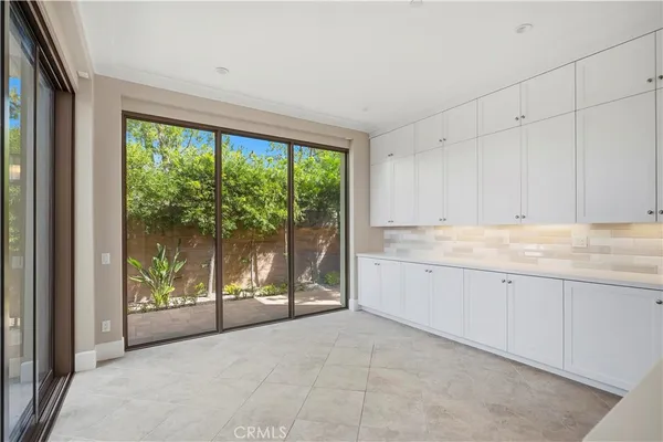 a large white kitchen with granite countertop a large counter top and stainless steel appliances