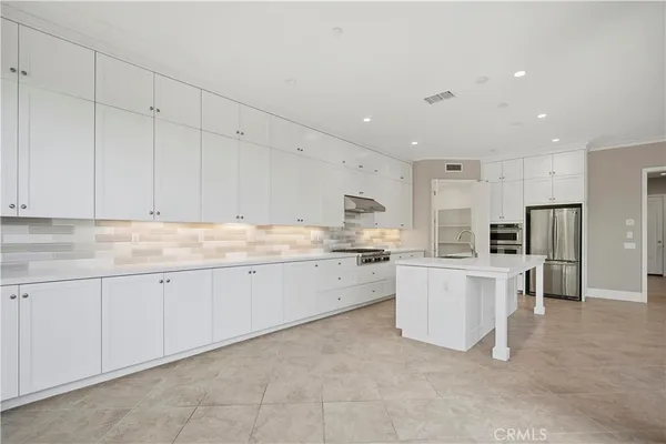 a view of kitchen with furniture a refrigerator and a view of living room