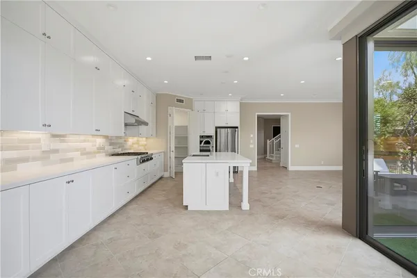 a large white kitchen with a stove a sink dishwasher and a refrigerator