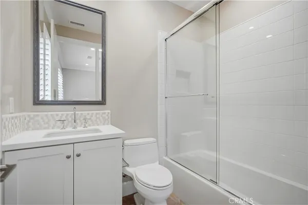 a view of an empty room with wooden floor and closet
