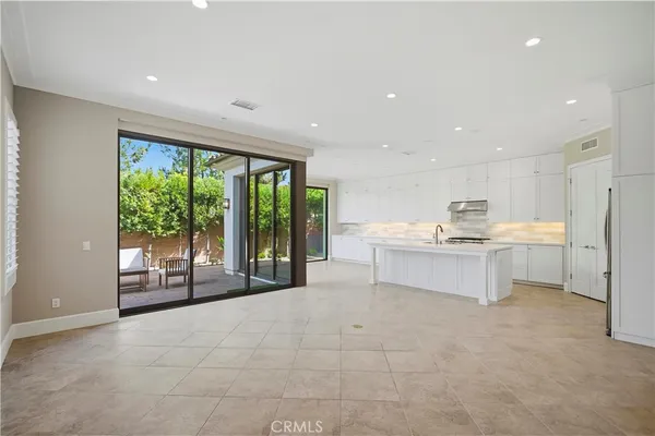 a kitchen with stainless steel appliances kitchen island granite countertop a refrigerator and a sink