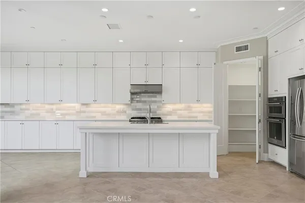a large white kitchen with a large window
