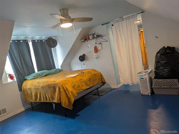 a bed sitting in a bedroom next to a window